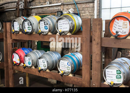 L'Angleterre, Tunbridge Wells. CAMRA vraie bière beer festival tenu à faire de la locomotive. Deux rangées de fûts de bière étiquetée sur les étagères, tous les exploiter. Banque D'Images