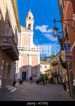 Rue étroite dans l'ombre et la façade de l'église de Santa Croce dans le centre-ville de Moneglia, Ligurie, Italie. Banque D'Images