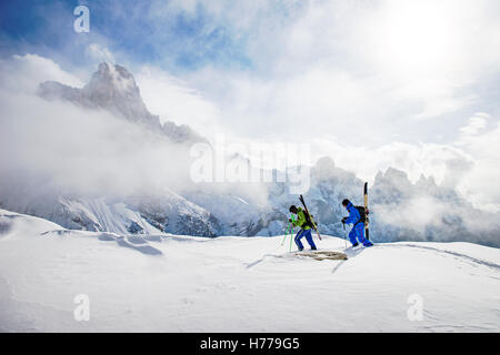 Deux skieurs marcher dans les Dolomites avec skies sur leur dos, le Tyrol du Sud, Italie Banque D'Images