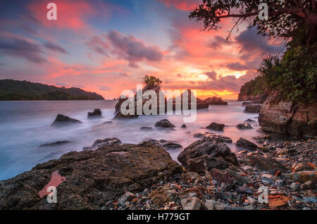 Côte Rocheuse au coucher du soleil, Pegadung Beach, Lampung, Indonésie Banque D'Images