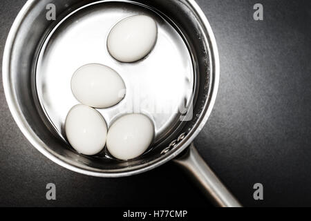 Quatre œufs dans une casserole d'eau Banque D'Images