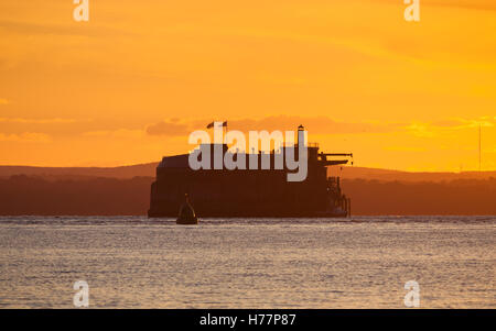 Le soleil qui illumine le ciel orange sur-fonds dans le Solent Banque D'Images