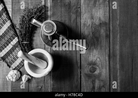 Vue aérienne de la vie toujours des ingrédients pour assaisonner de thym, l'ail et d'une burette, sur une table en bois rustique en noir et Banque D'Images