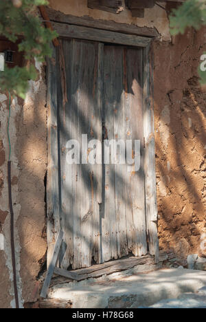 Vieille porte en bois miteux bleu avec charnières rouillées à l'entrée de la vieille maison en pierre chypriote. (Phikardou Fikardou) village. Chypre. Banque D'Images