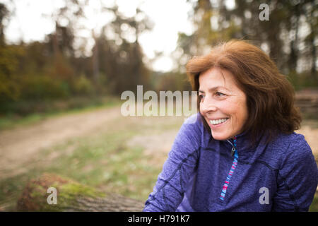 Hauts runner assis sur des troncs, couple, souriant. Banque D'Images