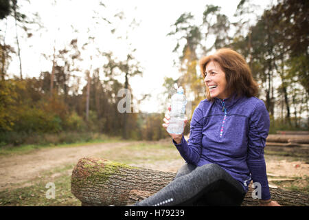 Hauts runner assis sur des troncs, le repos, l'eau potable. Banque D'Images