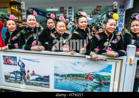 Les femmes vêtues de costumes Miao typique assistant à la parade de la Sœur du Festival Repas à l'autre de la route principale de Taijiang, province de Guizhou, Chine Banque D'Images