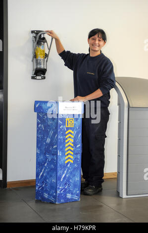Genève, Suisse - 13 janvier 2014 : jeune fille qui est le recyclage d'une bouteille de PET dans le contenant approprié dans la société cant Banque D'Images