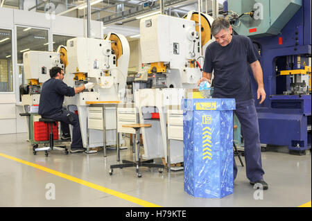 Genève, Suisse - 13 janvier 2014 : l'homme qui est le recyclage d'une bouteille de PET dans le contenant approprié dans le hall de l'industrie Banque D'Images