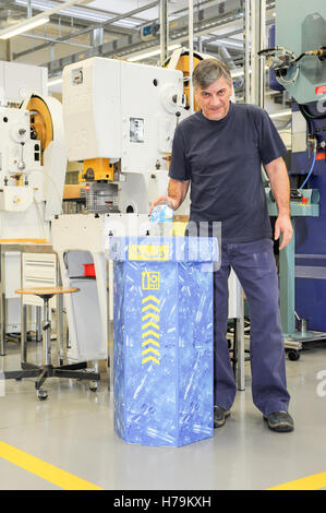 Genève, Suisse - 13 janvier 2014 : l'homme qui est le recyclage d'une bouteille de PET dans le contenant approprié dans le hall de l'industrie Banque D'Images