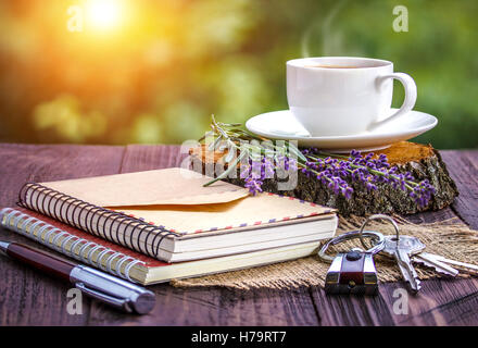 Ordinateur portable blanc vierge,les touches, Bouquet de lavande et de tasse de café sur le bureau à l'extérieur l'été Banque D'Images