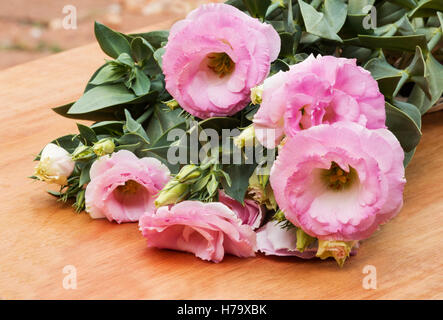 Lisianthus rose plante en fleur sur une table en bois Banque D'Images
