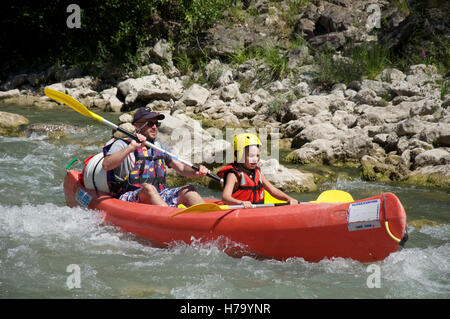 Le tourisme, les sports d'eau. Un père et son jeune fils en canoë sur les eaux à débit rapide de la Drôme. Près de Saillans, la Drôme, France. Banque D'Images