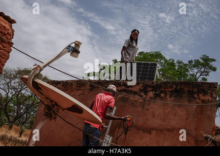 L'électrification rurale et de l'énergie solaire en Afrique subsaharienne. - 09/03/2016 - - Kourinion, Burkina Faso 9 Mars 2016 : les techniciens de la DSP Yeelen Ba, Julienne Sone et Bamogo Adrien, fraîchement recruté, viennent d'installer un équipement solaire pour la famille d'Omar Coulibaly. Omar's wedding est le jour suivant et à accueillir sa futur femme, il a installé l'électricité dans sa maison. - Nicolas Remene / Le Pictorium Banque D'Images