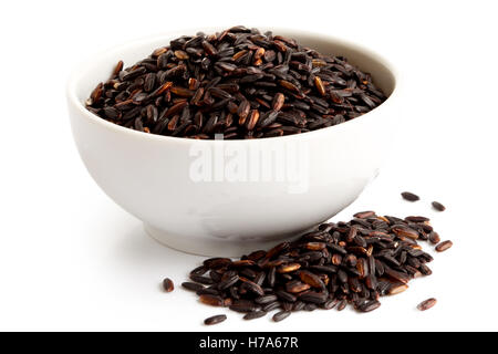 Bol de riz à grain long noir Nerone isolé sur blanc. Riz renversé. Banque D'Images