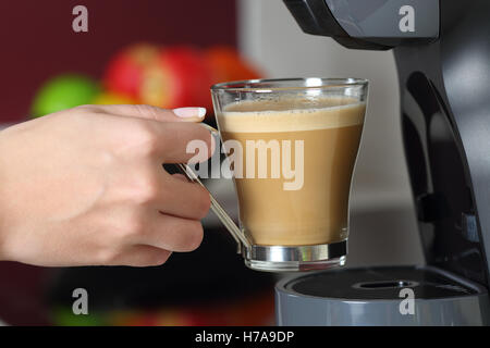 Close up of a woman holding a cup dans un café dans la cuisine à la maison Banque D'Images