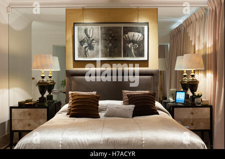 Illustrations botaniques au-dessus de lit lit double avec tables de chevet et lampes miroirs encastrés dans UK home Banque D'Images