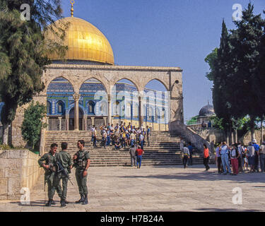 Jérusalem, Israël. 4ème Apr, 1988. Les touristes se rassemblent pour une photo de groupe à la célèbre 7e siècle golden Dôme du Rocher (en arabe : Qubbat al-á¹¢akhrah), un sanctuaire musulman sur le mont du Temple dans la vieille ville de Jérusalem. Trois soldats des FDI assurent la sécurité au premier plan. C'est un chef-d de l'architecture islamique, le site touristique par excellence, et site du patrimoine mondial de l'UNESCO. © Arnold Drapkin/ZUMA/Alamy Fil Live News Banque D'Images