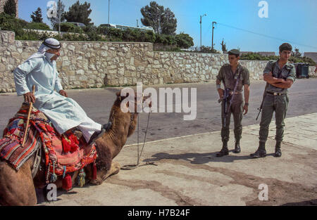 Jérusalem, Israël. 4ème Apr, 1988. Deux FDI (Forces de défense israéliennes) soldats en patrouille au point d'observation au-dessus du Mont des Oliviers à Jérusalem, arrêt pour voir un arabe au sommet de son repos camel utilisé comme un accessoire pour photographier des touristes. © Arnold Drapkin/ZUMA/Alamy Fil Live News Banque D'Images