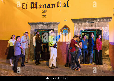 Les spectateurs l'étape d'une cantina pour regarder des centaines de gens habillés comme le squelette mariée la Calavera Catrina parade lors de la dernière journée de la Journée de la fête des morts le 2 novembre 2016 à San Miguel de Allende, Guanajuato, Mexique. La semaine de célébration est un moment où les Mexicains bienvenue les morts à la terre pour une visite et célébrer la vie. Banque D'Images