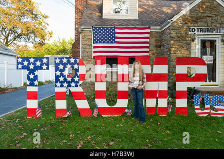 Bellmore, United States. 09Th Nov, 2016. Bellmore, New York, USA. Le 2 novembre 2016. EILEEN FUSCALDO, un défenseur Donald Trump, se place en avant de l'EMPORTER SUR L'affichage, l'un des nombreux dans sa cour avant pour le candidat présidentiel républicain, D. J. Trump, et contre l'un démocratique, H. R. Clinton. Sur sa porte d'entrée est une holding d'atout en carton "La majorité silencieuse est avec Trump'. Credit : Ann E Parry/Alamy Live News Banque D'Images