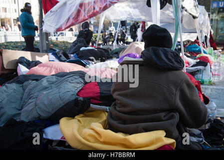 Munich, Allemagne. 4ème Nov, 2016. Un réfugié est couvert de plusieurs vestes par le camp de réfugiés de Sendlinger Tor entre plusieurs autres réfugiés couverts dans des couvertures et des sacs de couchage à Munich, Allemagne, 4 novembre 2016. Environ 80 réfugiés dans le camp, surtout parmi les états d'Afrique, maintenant aussi à s'abstenir de boire après cinq yeatrs de grève de la faim. Ils demandent un droit de résidence et d'un terme à l'expulsion dans des soi-disant pays d'origine sûr. PHOTO : MATTHIAS BALK/dpa/Alamy Live News Banque D'Images