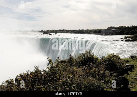 Une vue sur les chutes du Niagara sur le site canadien avec la rivière qui coule sur le bord et la brume à venir. Banque D'Images