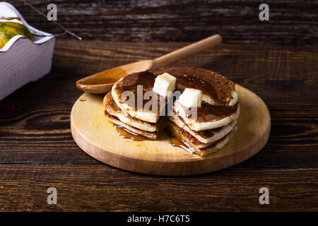 Crêpes maison servi chaud avec du beurre et du sirop d'érable sur la table en bois rustique Banque D'Images