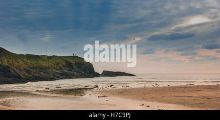 Deux minuscules figures debout sur la pointe de fournir à l'échelle d'un grand terre ciel et mer paysage. Clonakilty, Irlande, 2016. Banque D'Images