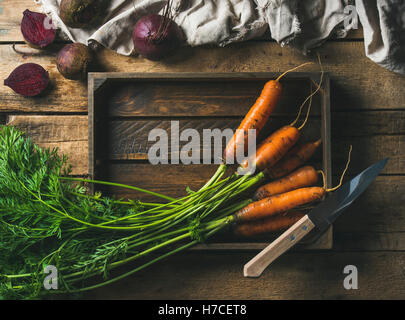 Arrière-plan de cuisson des aliments sains. Ingrédients de légumes. Frais jardin les carottes et les betteraves en plateau en bois au bac en bois rustique Banque D'Images