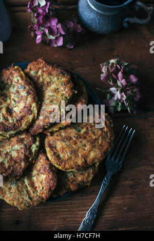 La Courgette, la carotte et fromage beignets sur une plaque sur une table en bois rustique Banque D'Images