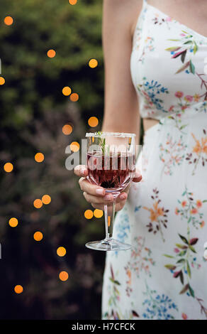 Femme tenant un cocktail dans la main Banque D'Images