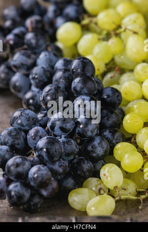 Grappes de mûres rouges et humides de raisin blanc sur fond métal texture vieux. Close up Banque D'Images