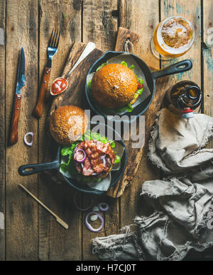 Hamburgers dans les casseroles de fer de fonte et verre de bière Banque D'Images