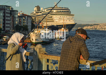 Une dame âgée angles à partir de pont de Galata. Un grand bateau de croisière est amarré le long du front de mer de Karaköy. Banque D'Images