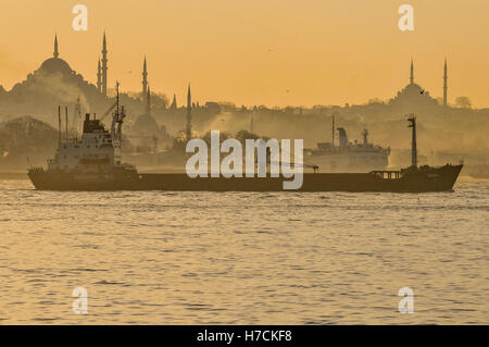 Un cargo voiles passé l'horizon du quartier historique de Sultanahmet et Fatih à Istanbul, au coucher du soleil. Les minarets de Su Banque D'Images