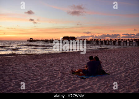 Couple sur la plage de sable près de l'ossature avec Naples, Floride pier derrière Banque D'Images