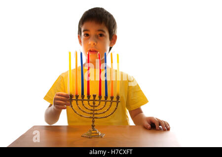 Un enfant de 8 ans un éclairage Hanukkah Menorah Banque D'Images