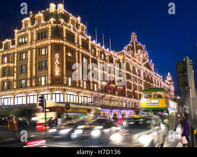 HARRODS SOLDE BLUR LIGHTS ULEZ Harrods grand magasin la nuit avec le panneau « Sale » éclairé shoppers Harrods tour bus et taxis Knightsbridge Londres SW1 Banque D'Images