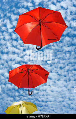 Parasols aux couleurs vives contre un ciel tacheté de nuages, décorant une rue commerçante à Barcelos, Portugal Banque D'Images