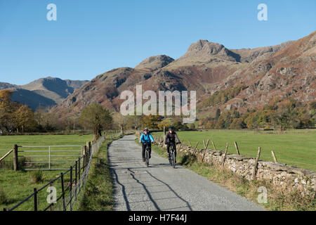 Un couple à vélo dans la vallée de Langdale, Lake District, UK. Banque D'Images