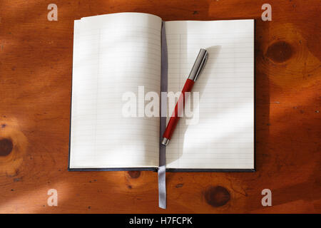 Journal vierge ouvert avec stylo plume sur un bureau en bois. Banque D'Images