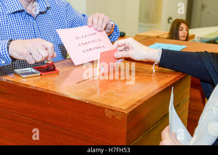 Lugano, Suisse - 11 avril 2016 : mettre la main un bulletin de vote dans une fente de boîte en bois à l'élection municipale de Lugano sur Banque D'Images