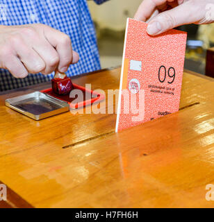 Lugano, Suisse - 11 avril 2016 : mettre la main un bulletin de vote dans une fente de boîte en bois à l'élection municipale de Lugano sur Banque D'Images