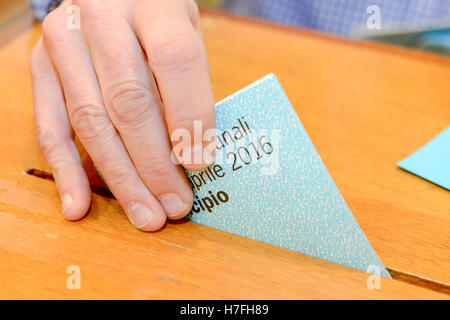 Lugano, Suisse - 11 avril 2016 : mettre la main un bulletin de vote dans une fente de boîte en bois à l'élection municipale de Lugano sur Banque D'Images