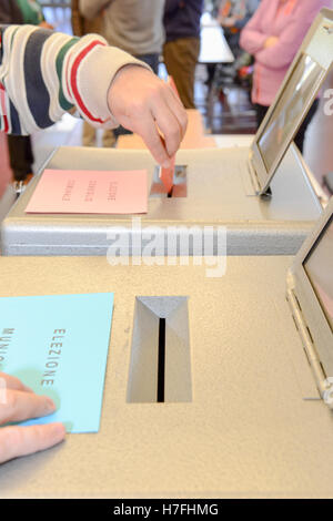 Lugano, Suisse - 11 avril 2016 : mettre la main un bulletin de vote dans une fente de boîte en bois à l'élection municipale de Lugano sur Banque D'Images