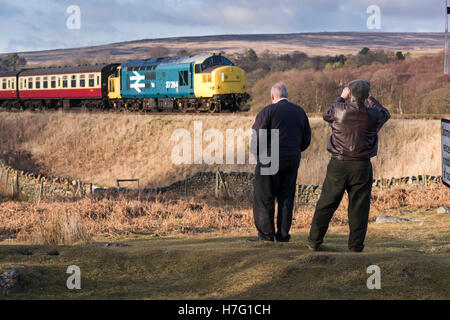 Les amateurs de trains watch BR Class 37' 'Co-Co no 37264 locomotive diesel voyageant sur le North Yorkshire Moors Railway, FR, UK. Banque D'Images