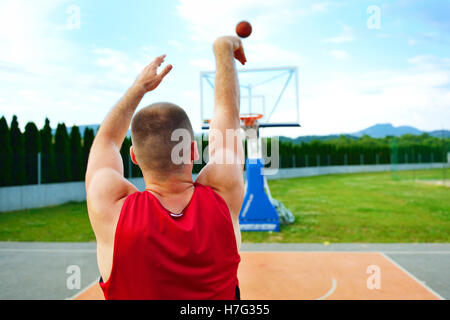 Vue arrière d'un joueur de basket-ball, tir à l'extérieur du panier Banque D'Images
