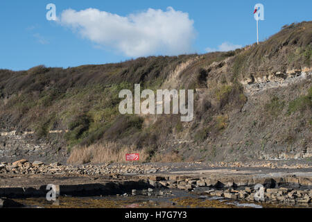Les panneaux d'avertissement et de drapeaux rouges à Kimmeridge Bay, Dorset Banque D'Images