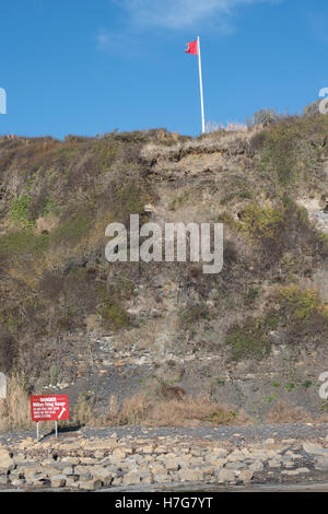 Les panneaux d'avertissement et de drapeaux rouges à Kimmeridge Bay, Dorset Banque D'Images